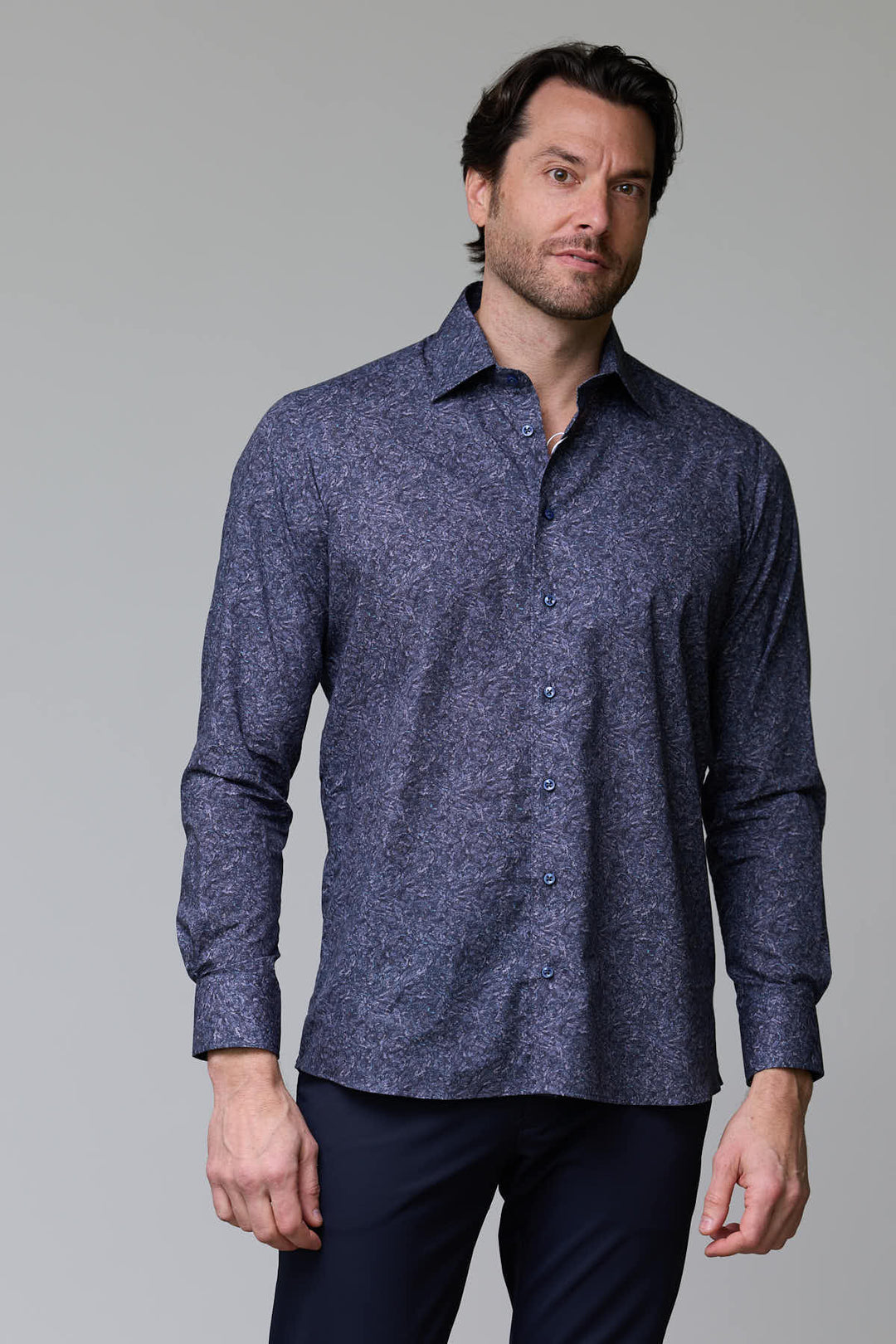 Homme portant une chemise à motif texturé bleu avec col semi-rigide et boutons assortis, parfait pour des occasions professionnelles.