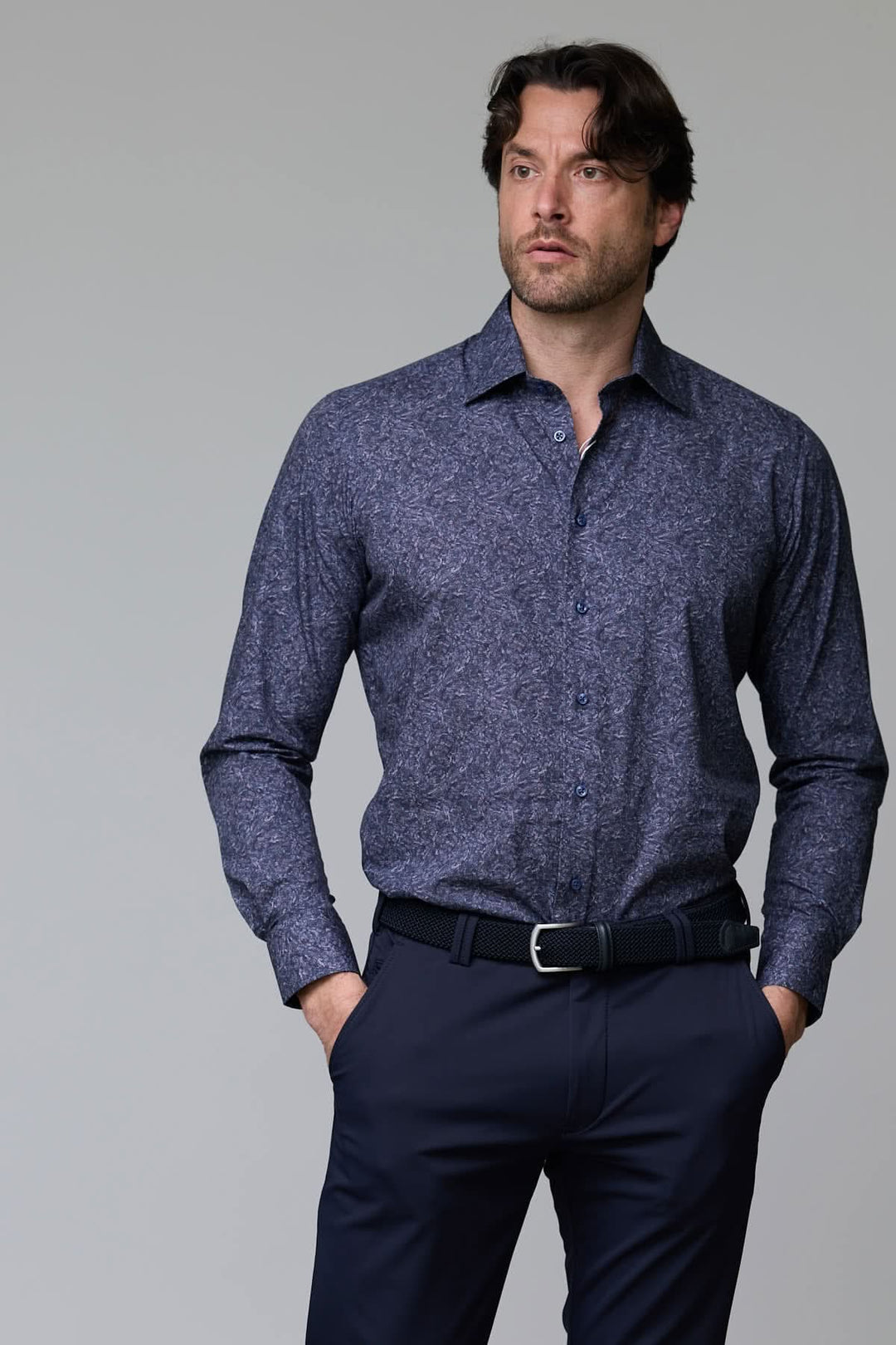 Homme portant une chemise à motif texturé bleue avec col semi-rigide et boutons assortis.