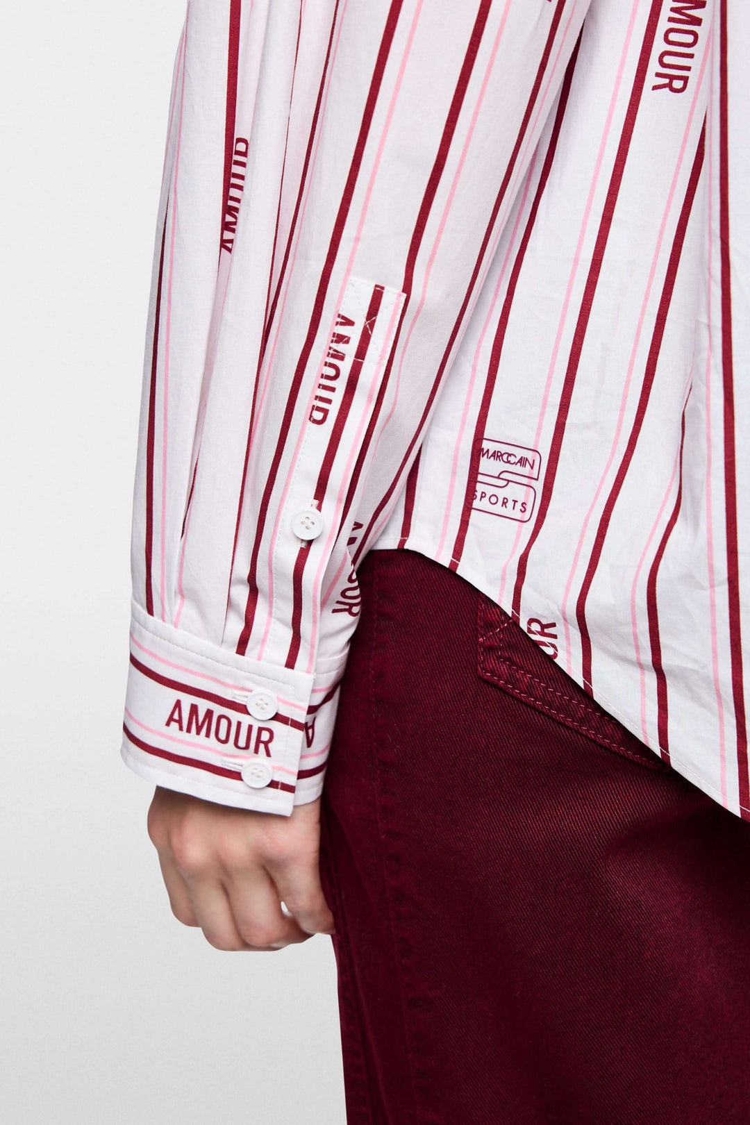 Chemise rayée en coton biologique avec inscriptions et manches boutonnées "Amour". Image de détail côté manche.