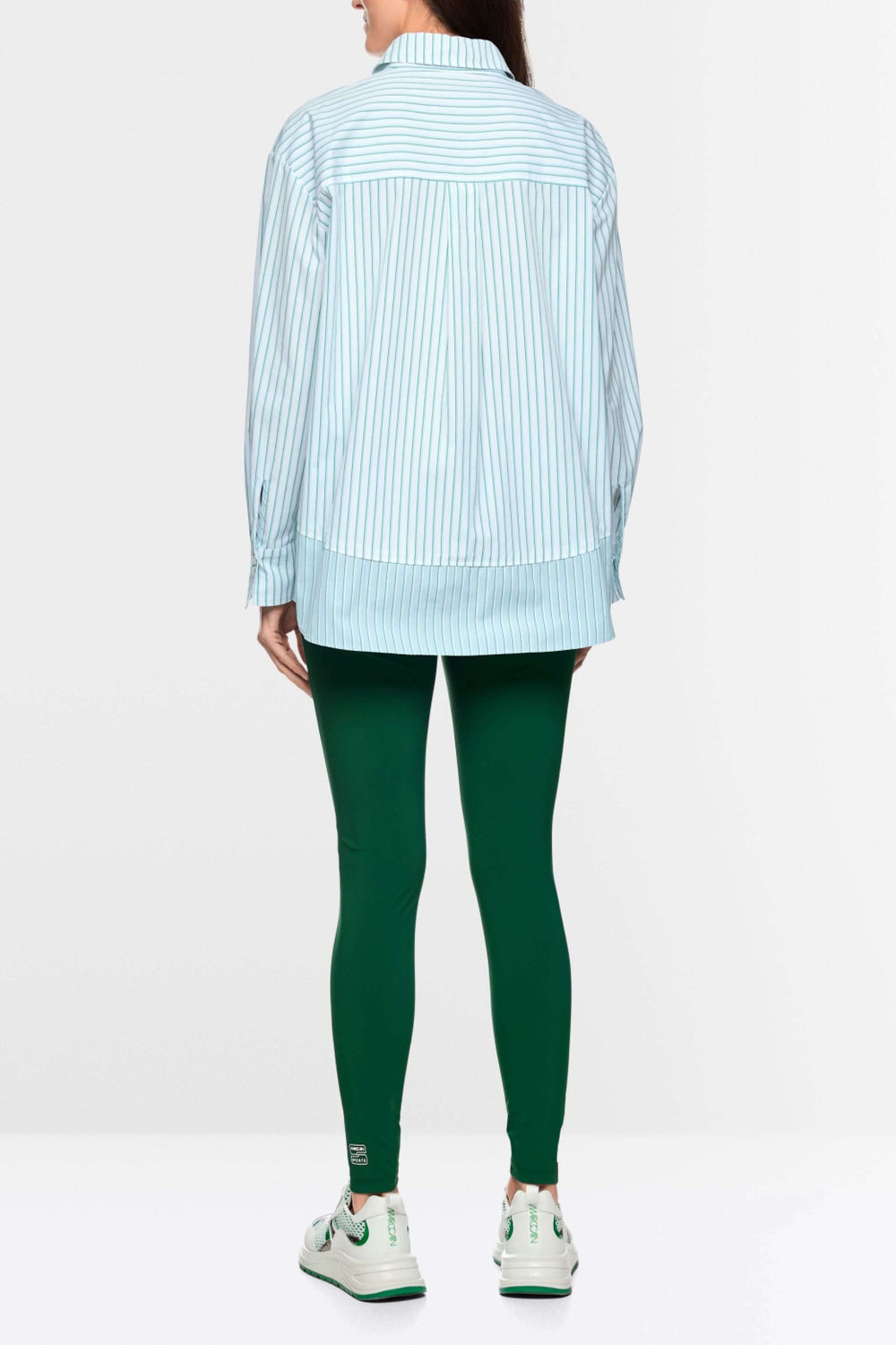 Chemise rayée en coton moderne avec coupe ample et col structuré, associée à un look décontracté.