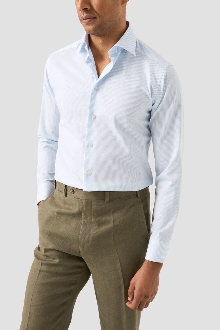 Homme portant une chemise rayée en coton et lyocell élégante, légère et raffinée, parfaite pour un style professionnel ou quotidien.