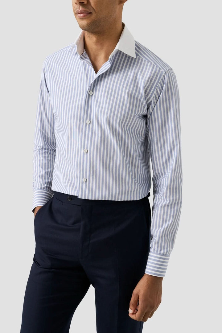 Chemise à rayures Bengal à col blanc portée avec un pantalon foncé, élégante et ajustée pour un style professionnel raffiné.