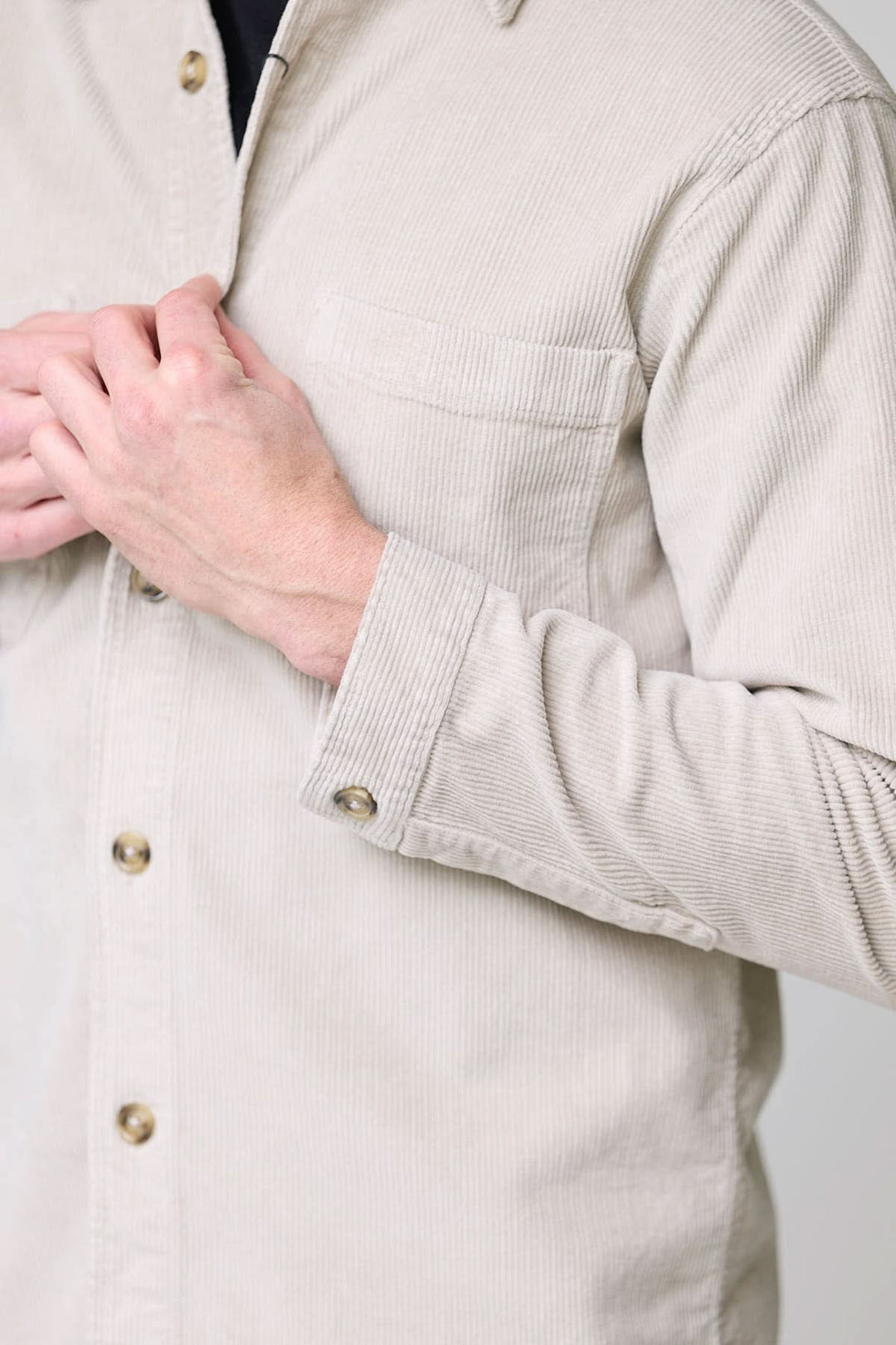 Homme portant une chemise sport en velours côtelé style surchemise avec une main sur la poitrine.