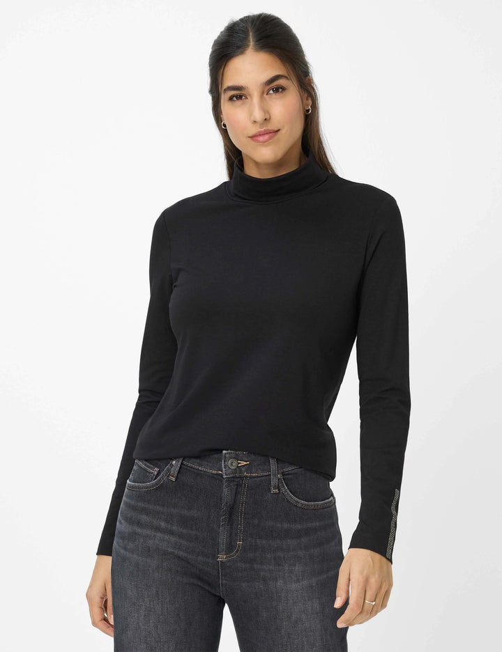 Femme portant un col roulé CARINA.L en jersey noir, doux et extensible, idéal pour un style quotidien polyvalent avec jeans ou blazer.