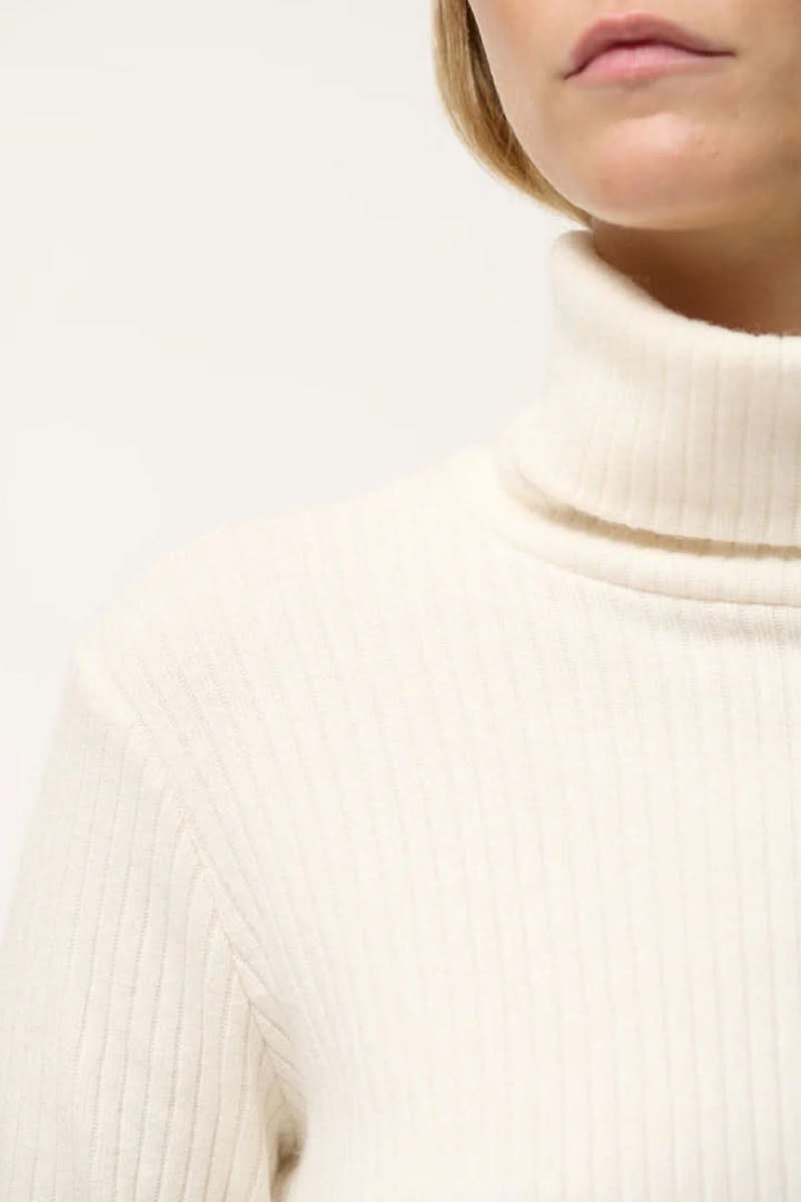 Col roulé côtelé élégant en jersey, manches longues et couleur crème, parfait pour le style décontracté ou habillé.