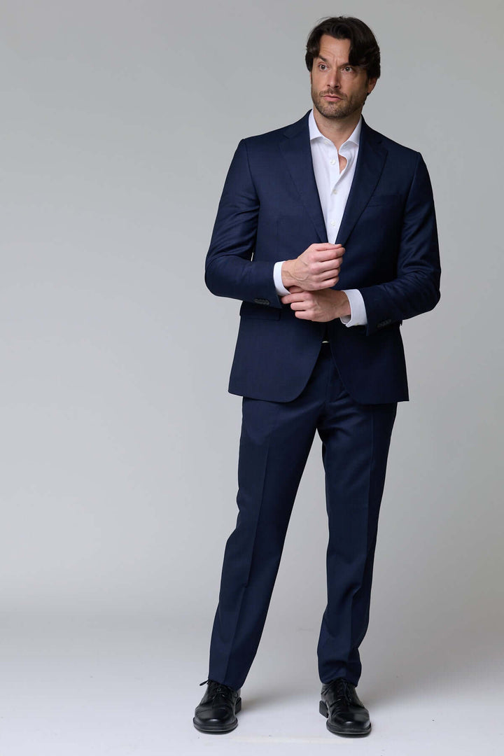 Homme portant un complet classique deux pièces bleu pour une apparence élégante et professionnelle.