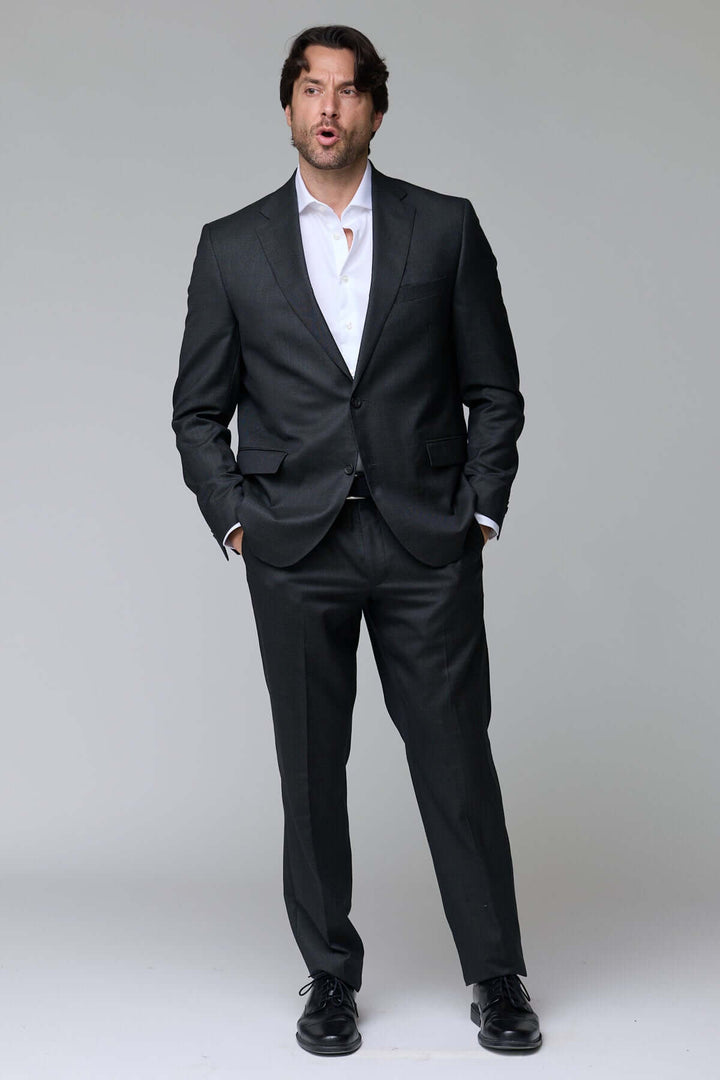 Homme portant un complet classique deux pièces élégant et ajusté, idéal pour événements et bureau. Décris moi le produit en français.