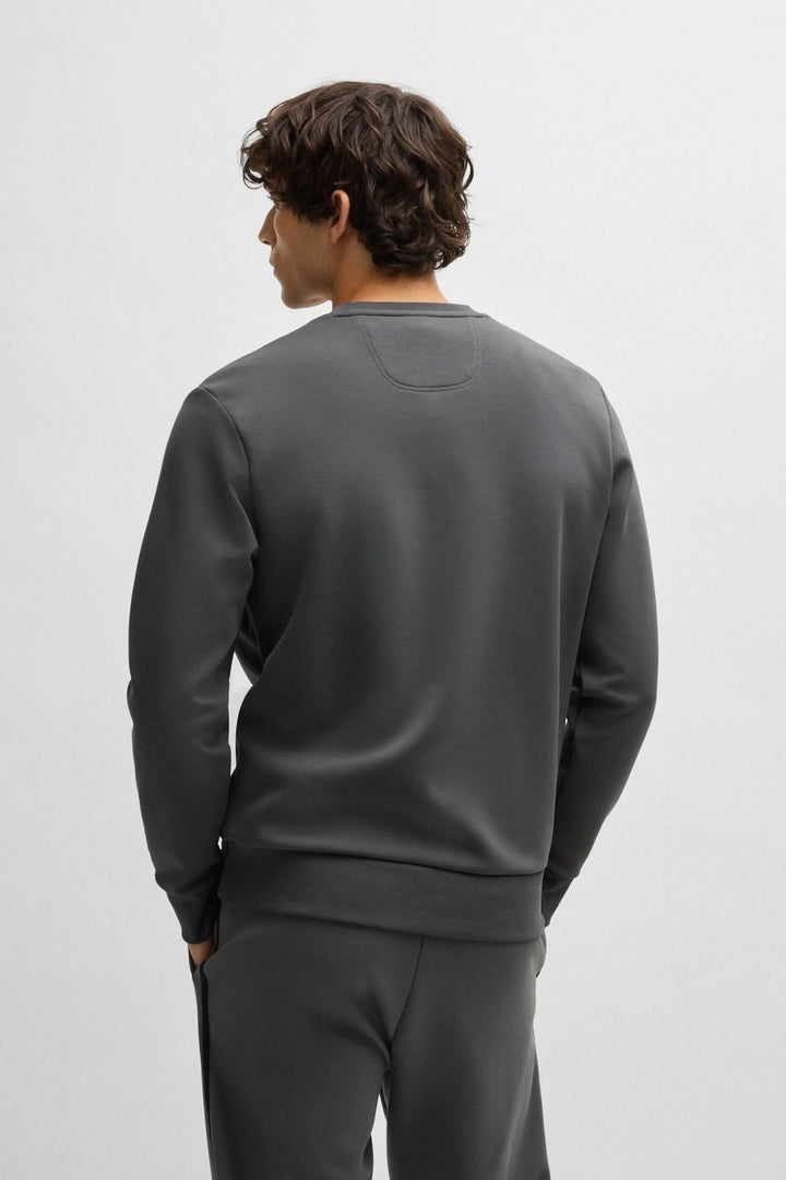 Homme portant un chandail en coton ouaté gris, vu de dos, avec coupe confortable, parfait pour un look décontracté.