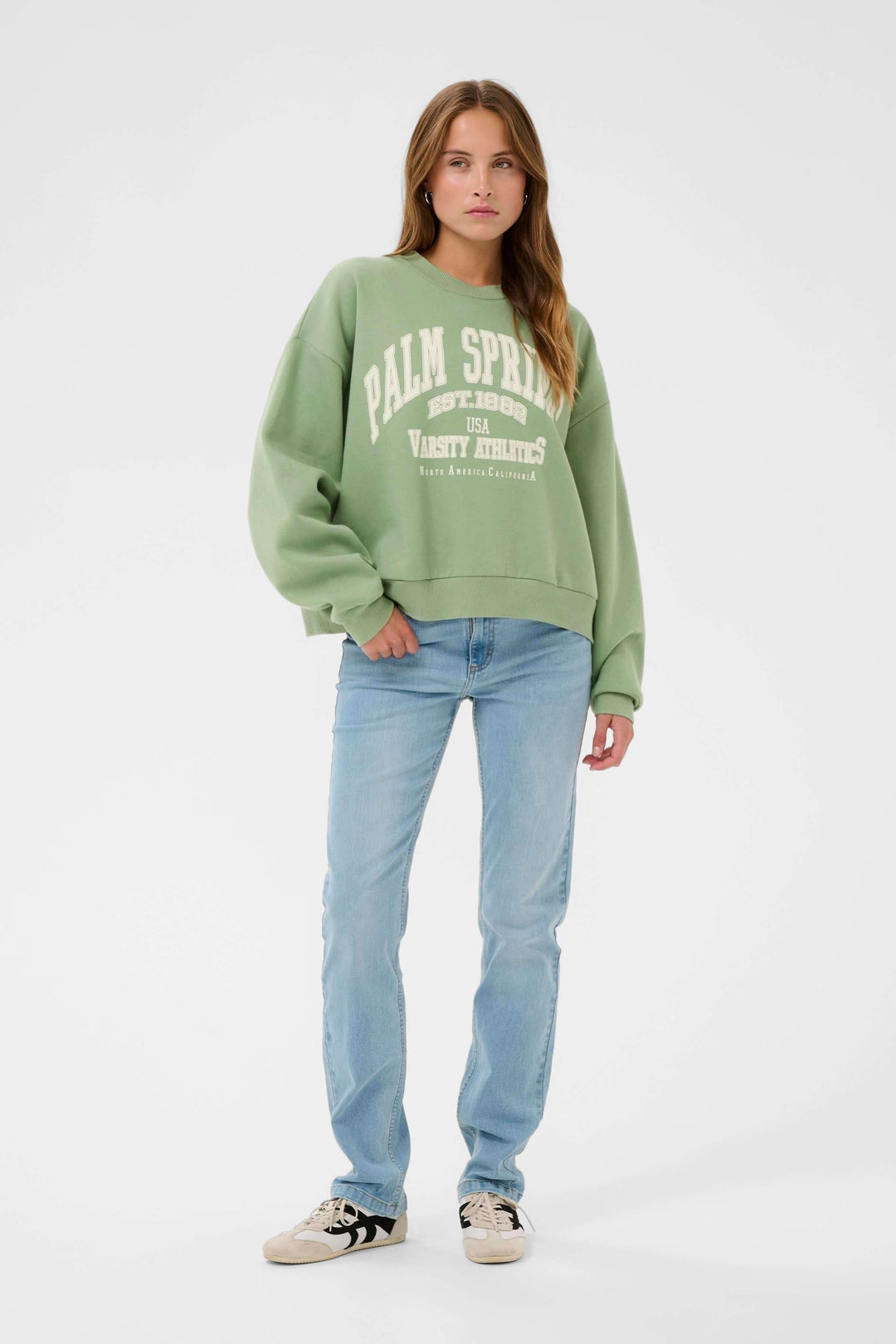Femme portant un coton ouaté Sussi style universitaire, coupe ample et confortable, vert avec motif imprimé à l&