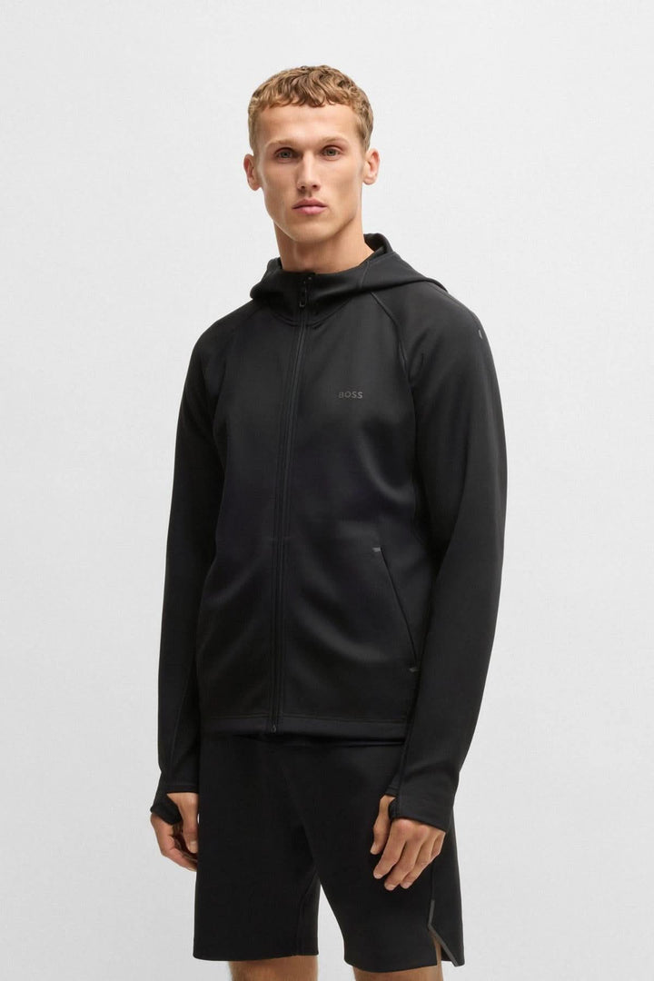 Homme portant une veste coton ouaté sportif BOSS noire avec capuche, idéal pour l'entraînement.