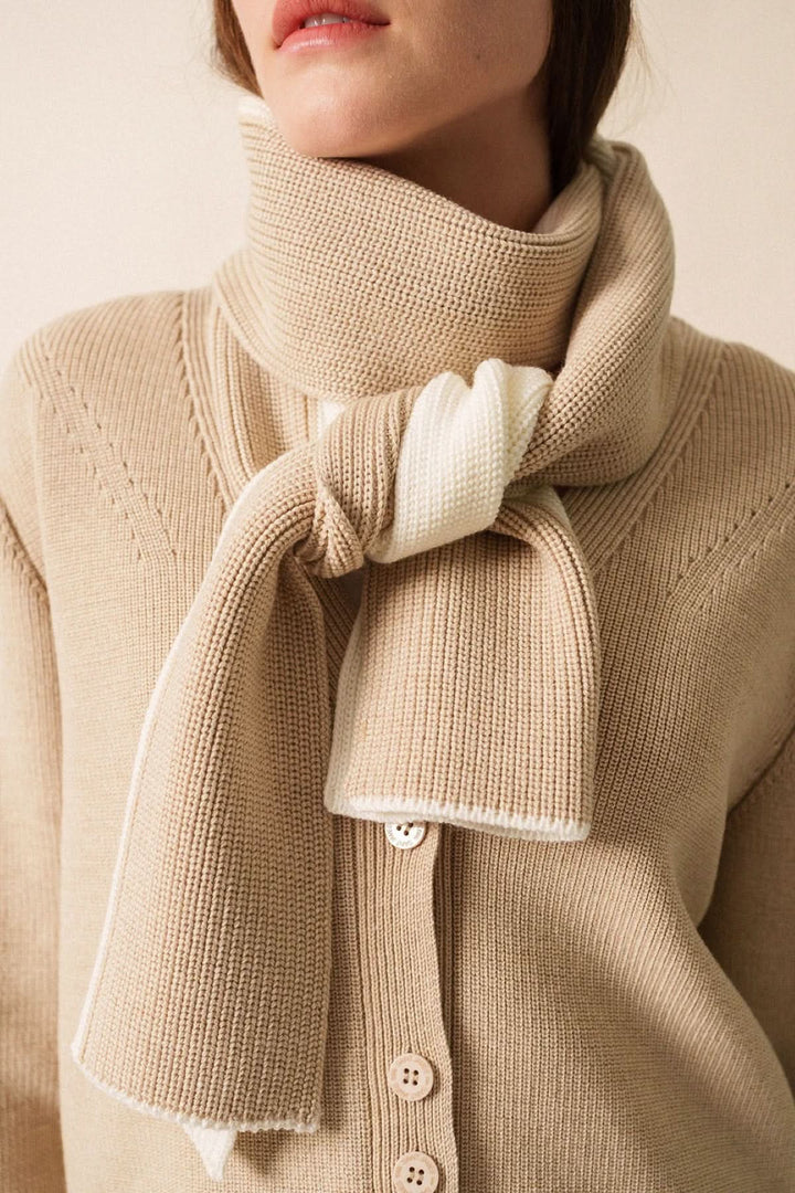 Foulard en maille bicolore, douceur et élégance décontractée, noué autour du cou pour un look cosy.