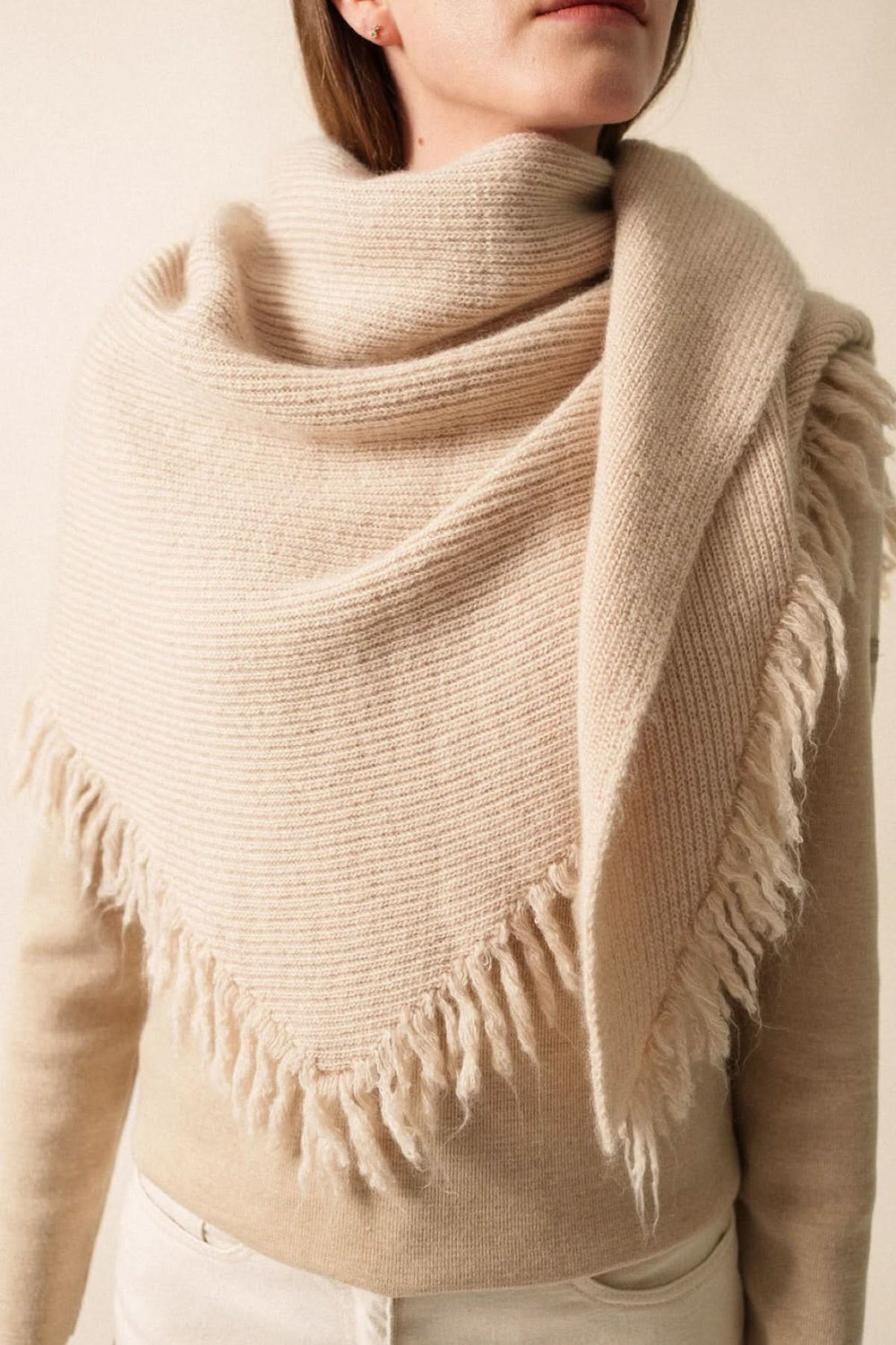 Foulard en maille douce beige avec franges, idéal pour une élégance décontractée et un look cosy.