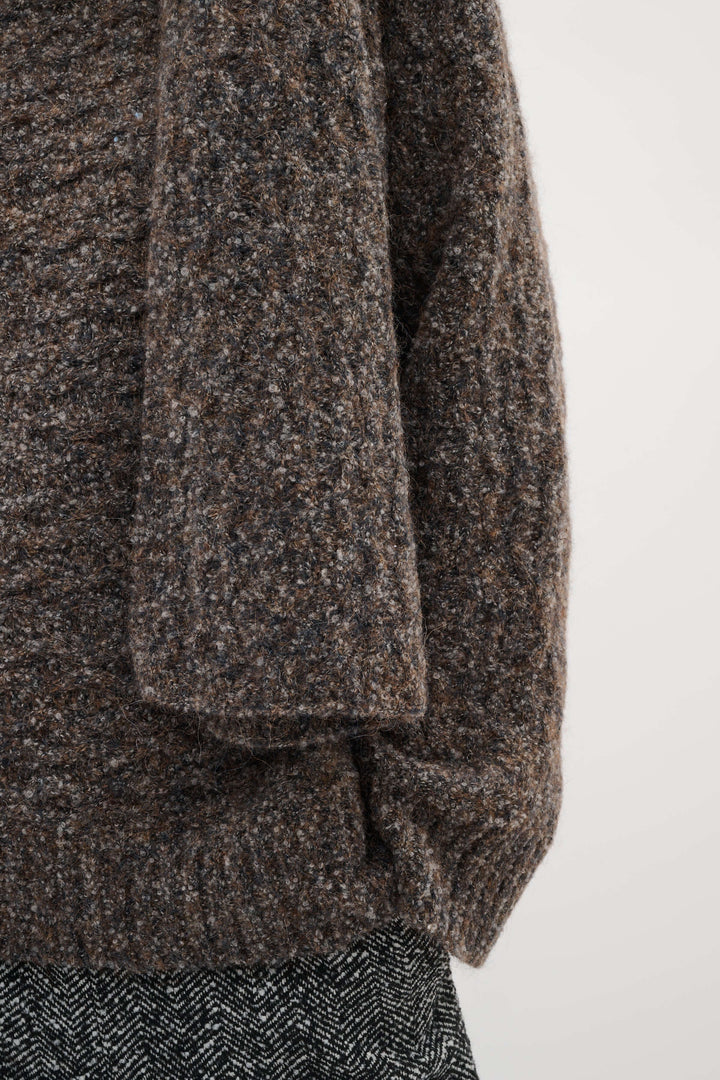 Foulard Graia en maille texturée offrant chaleur et style moderne, parfait pour les tenues hivernales élégantes.