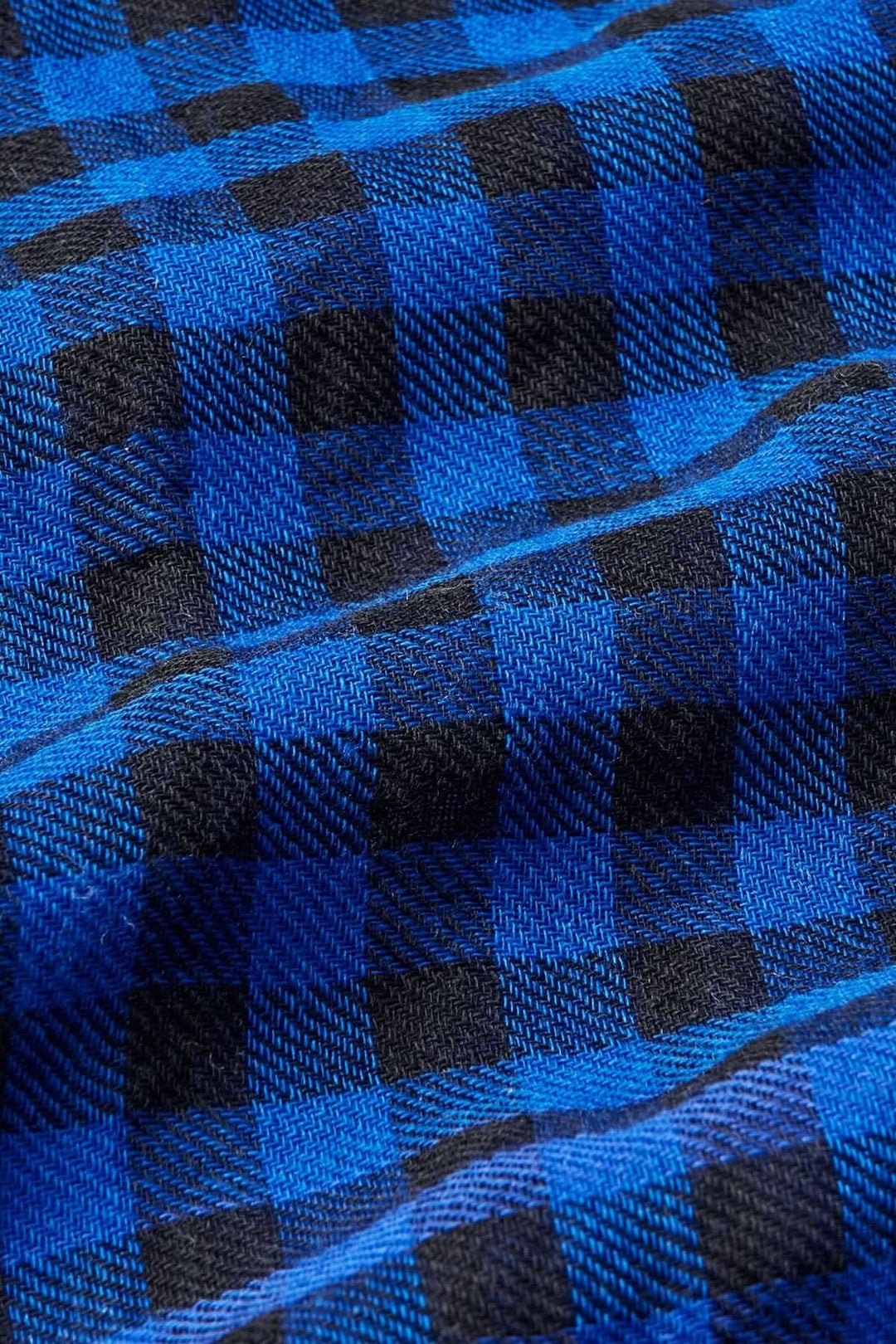 Tissu en écharpe à carreaux noirs et bleus, en laine fine, avec texture légèrement transparente.