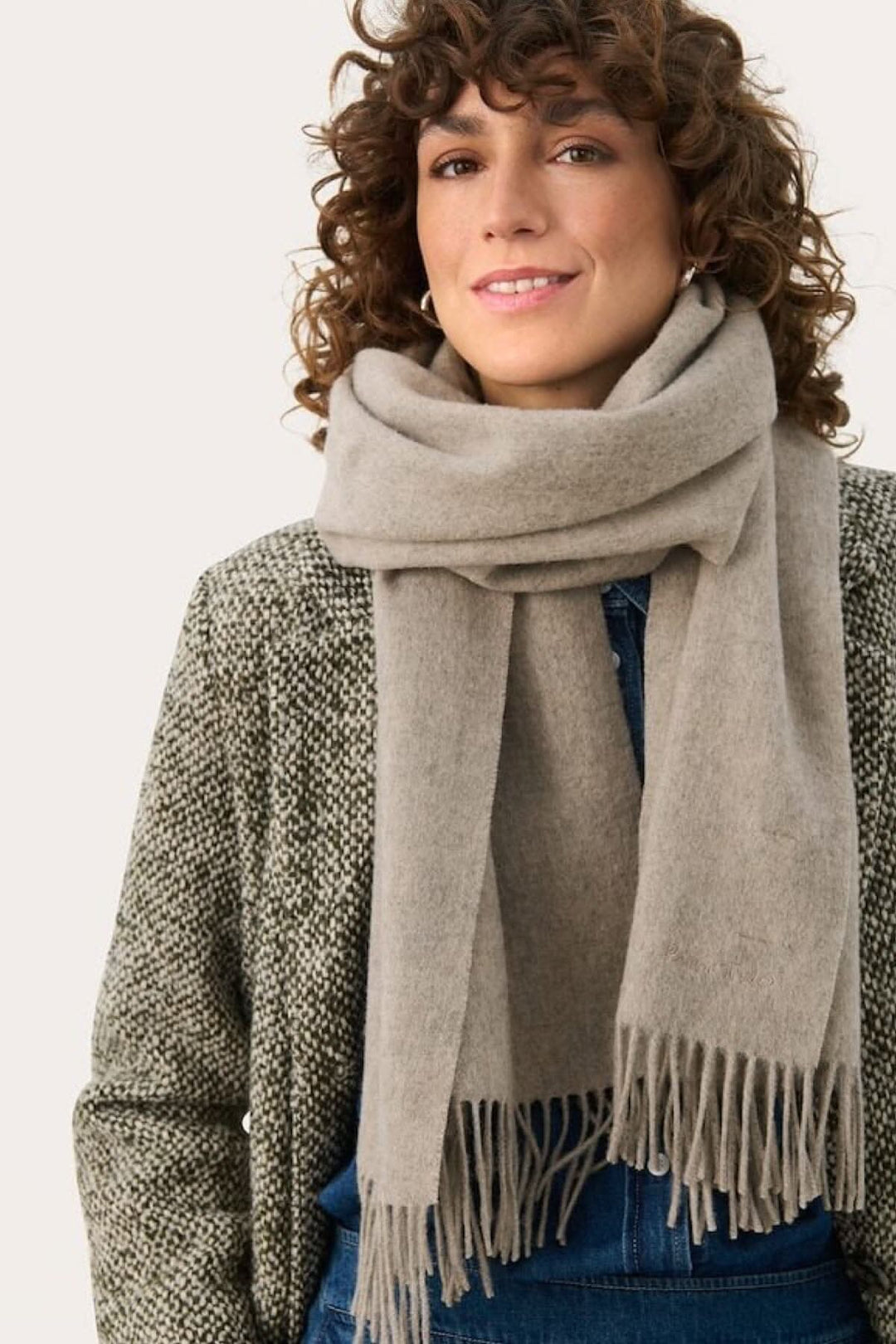 Foulard en laine Kitha, accessoire hiver en teintes harmonieuses, chaud et élégant, porté par une femme souriante.