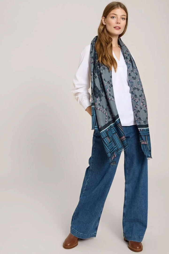Foulard imprimé lièvre porté avec un haut blanc et un pantalon en jean large, affichant des motifs géométriques.
