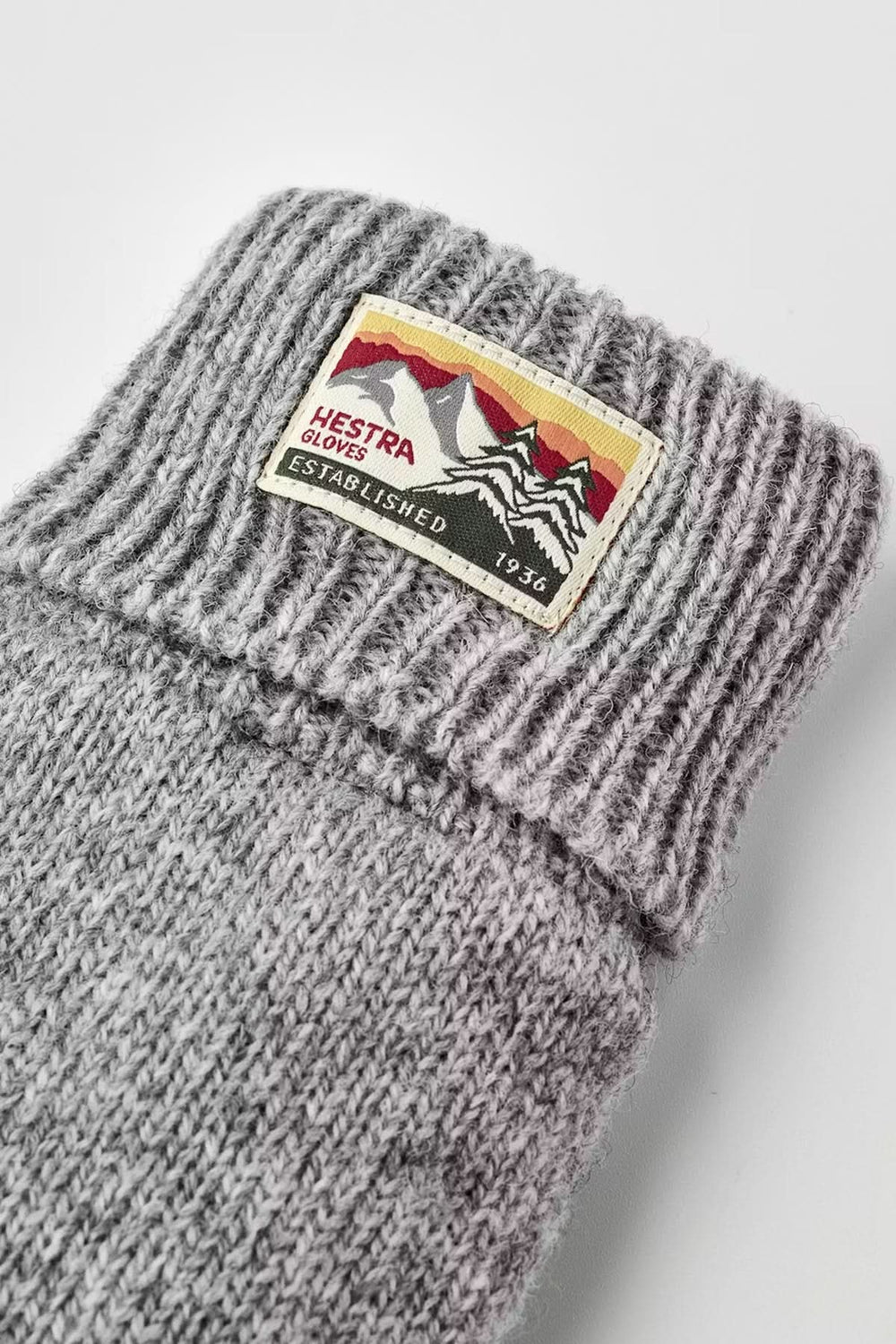 Gants en maille gris avec logo, offrant protection et confort pour les journées fraîches.