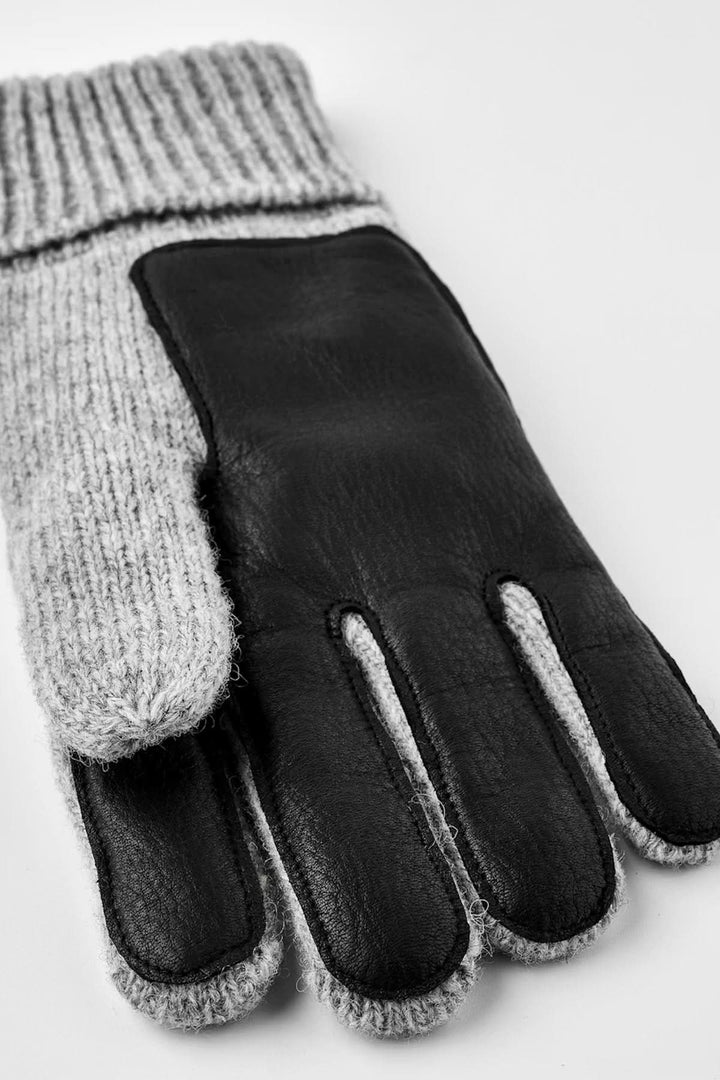 Gant en maille gris et noir avec poignets côtelés pour chaleur et confort, idéal pour temps frais.