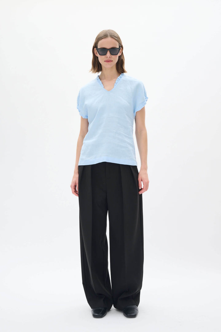 Haut en lin Rigitta à encolure en V, manches courtes, porté avec un pantalon noir, parfait pour l&