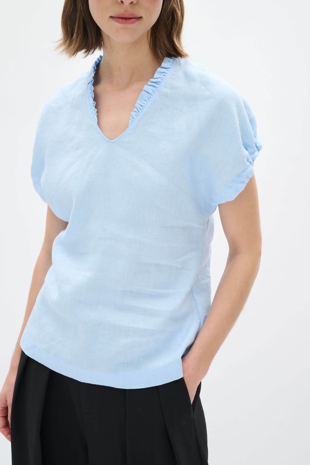 Haut en lin Rigitta bleu clair avec encolure en V et manches courtes retroussées, idéal pour l&