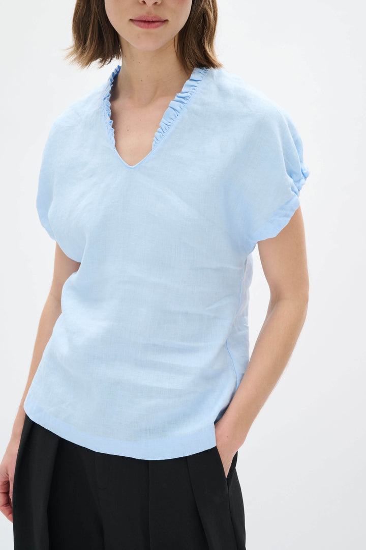 Haut en lin Rigitta bleu clair avec encolure en V et manches courtes retroussées, idéal pour l&