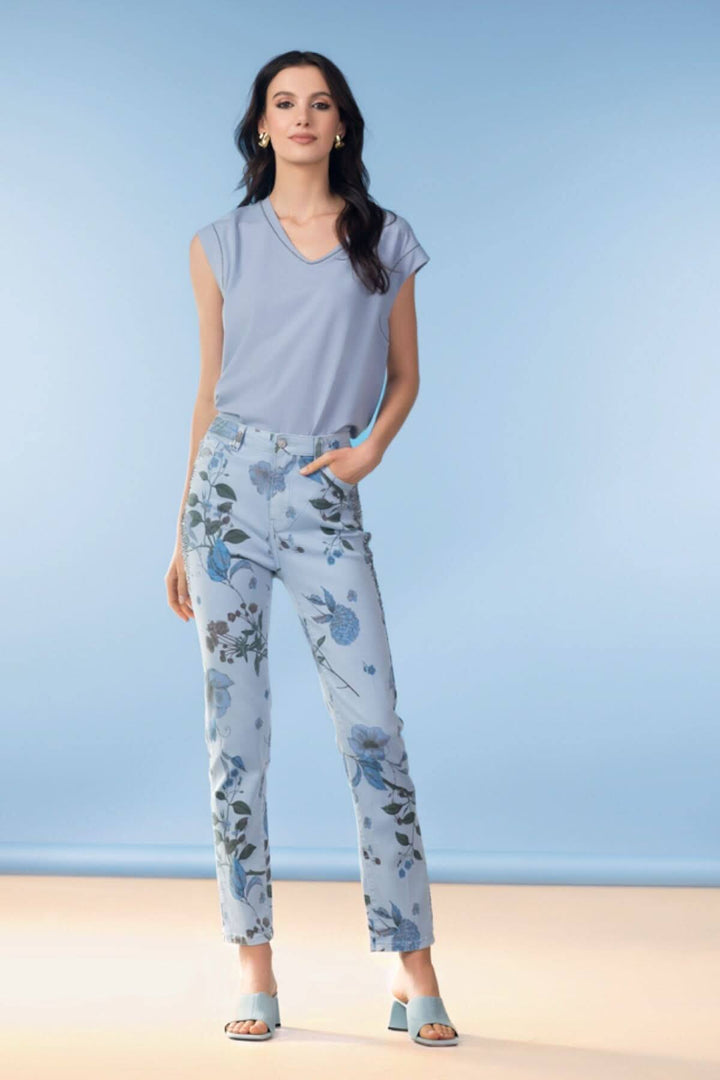 Femme portant un haut fluide col en V et un pantalon à imprimé floral, style moderne et élégant.