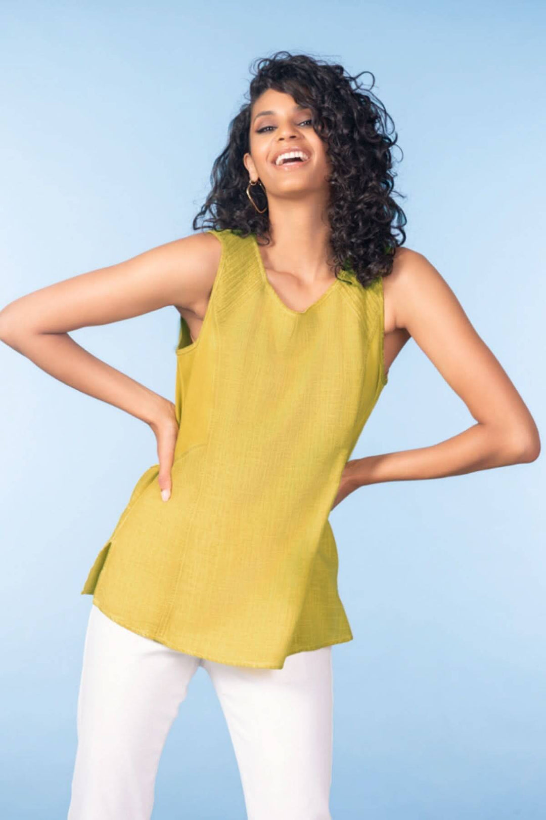 Femme portant un haut sans manches encolure ronde vert, allure décontractée et élégante.