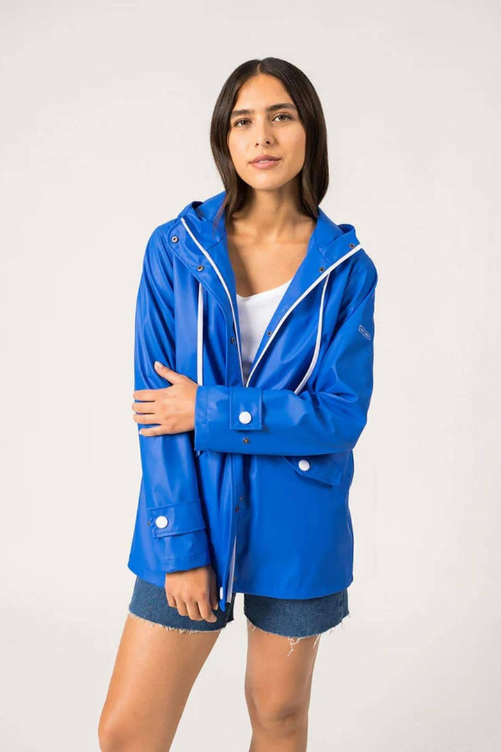 Femme portant un imperméable bleu Ste Gaia, léger et waterproof, parfait pour le printemps et les intempéries.