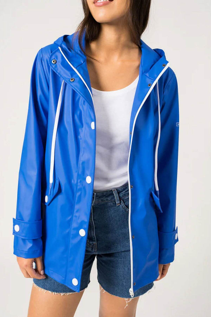 Femme portant un imperméable bleu, parfait pour le printemps, avec un style moderne et pratique.