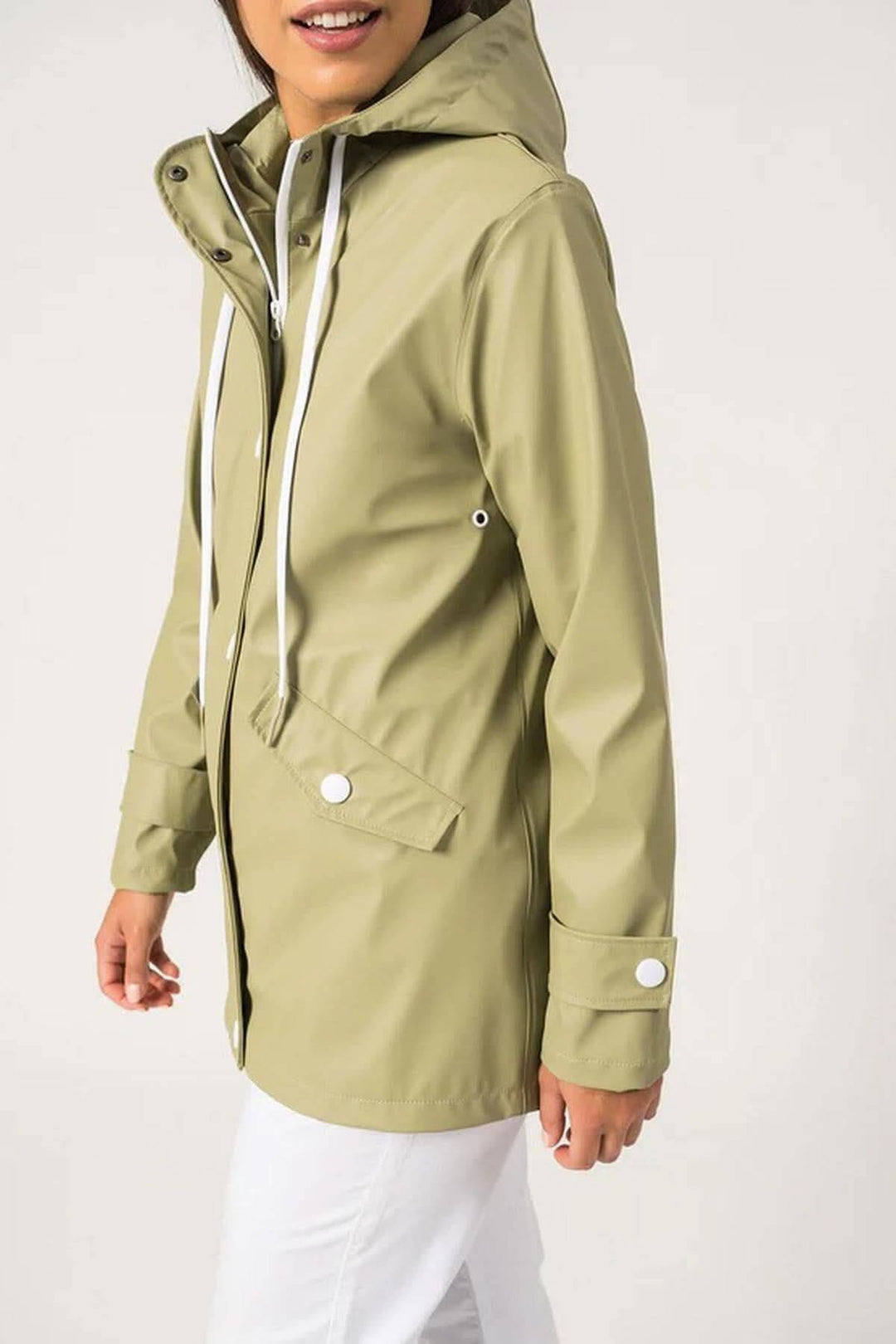 Femme portant un imperméable vert clair, modèle Ste Gaia, au style moderne et confortable.
