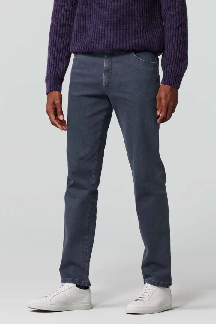Jean slim en denim biologique gris, offrant confort et liberté de mouvement, associé à un pull violet.