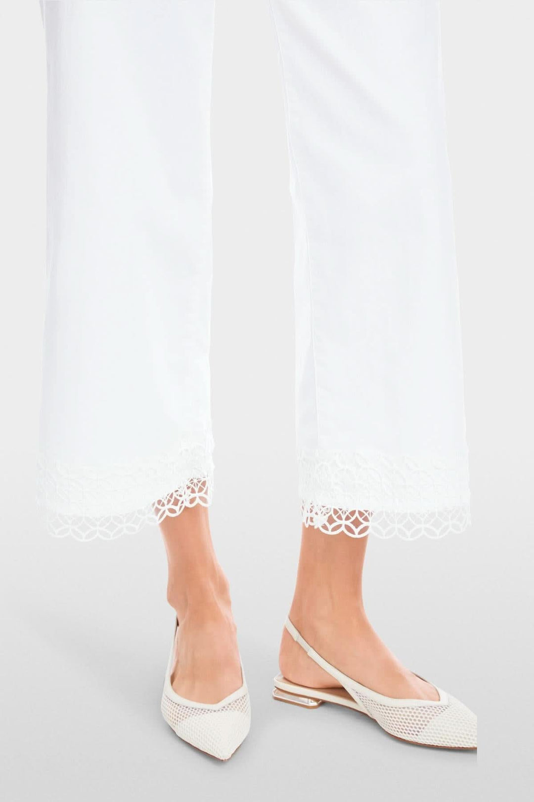 Jean Wigan avec dentelle, taille haute, ourlet délicat, porté avec des chaussures blanches, style élégant.