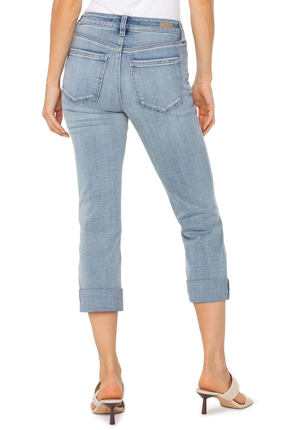 Jean capri à revers en denim délavé, coupe ajustée, deux poches arrière et ourlets modernes.