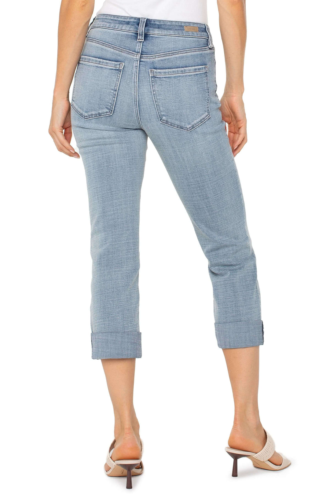 Jean capri à revers en denim délavé, coupe ajustée, deux poches arrière et ourlets modernes.