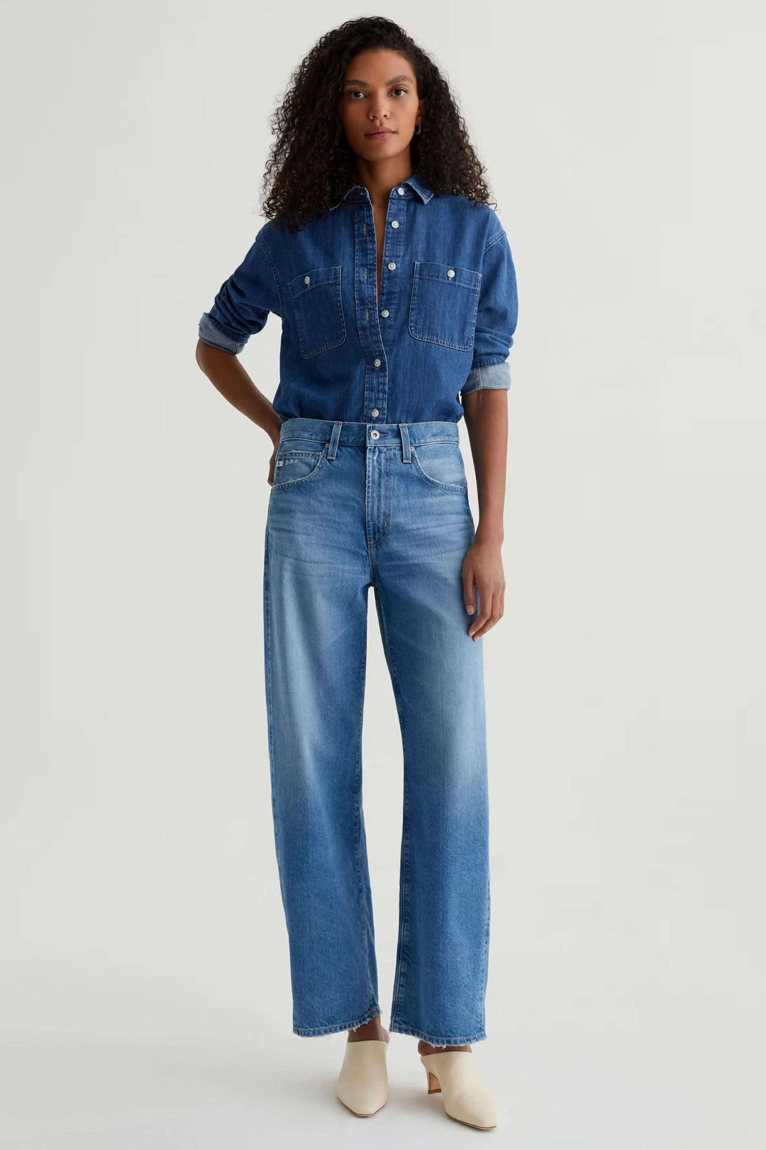 Jean droit à jambe large en denim, taille haute, minimaliste, idéal avec chemise ou chandail. Look moderne et décontracté.