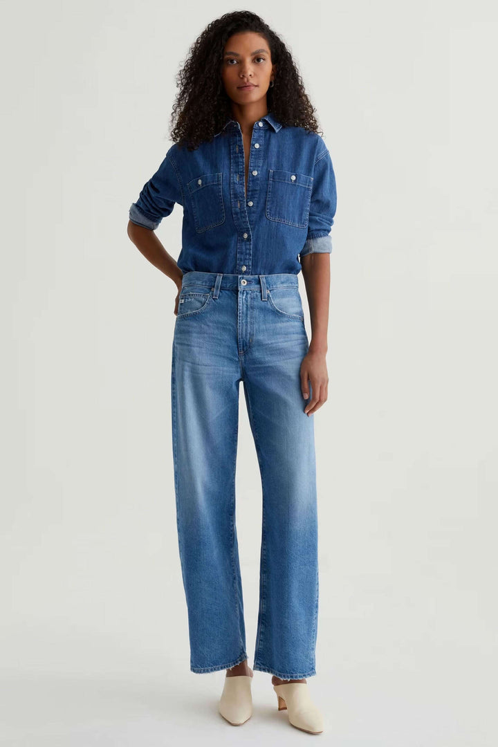 Jean droit à jambe large en denim, taille haute, minimaliste, idéal avec chemise ou chandail. Look moderne et décontracté.