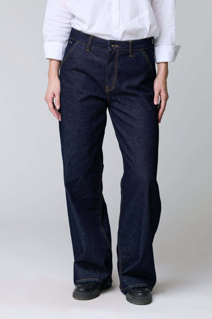 Jean à jambe large en denim brut avec coupe ample, détails surpiqués pour un look vintage et décontracté, offrant confort et style.