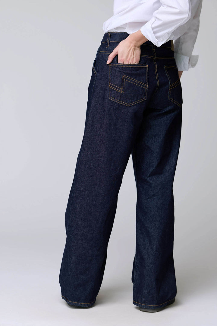 Jean à jambe large avec surpiqûres contrastantes et denim brut, offrant un style décontracté et une coupe droite ample.