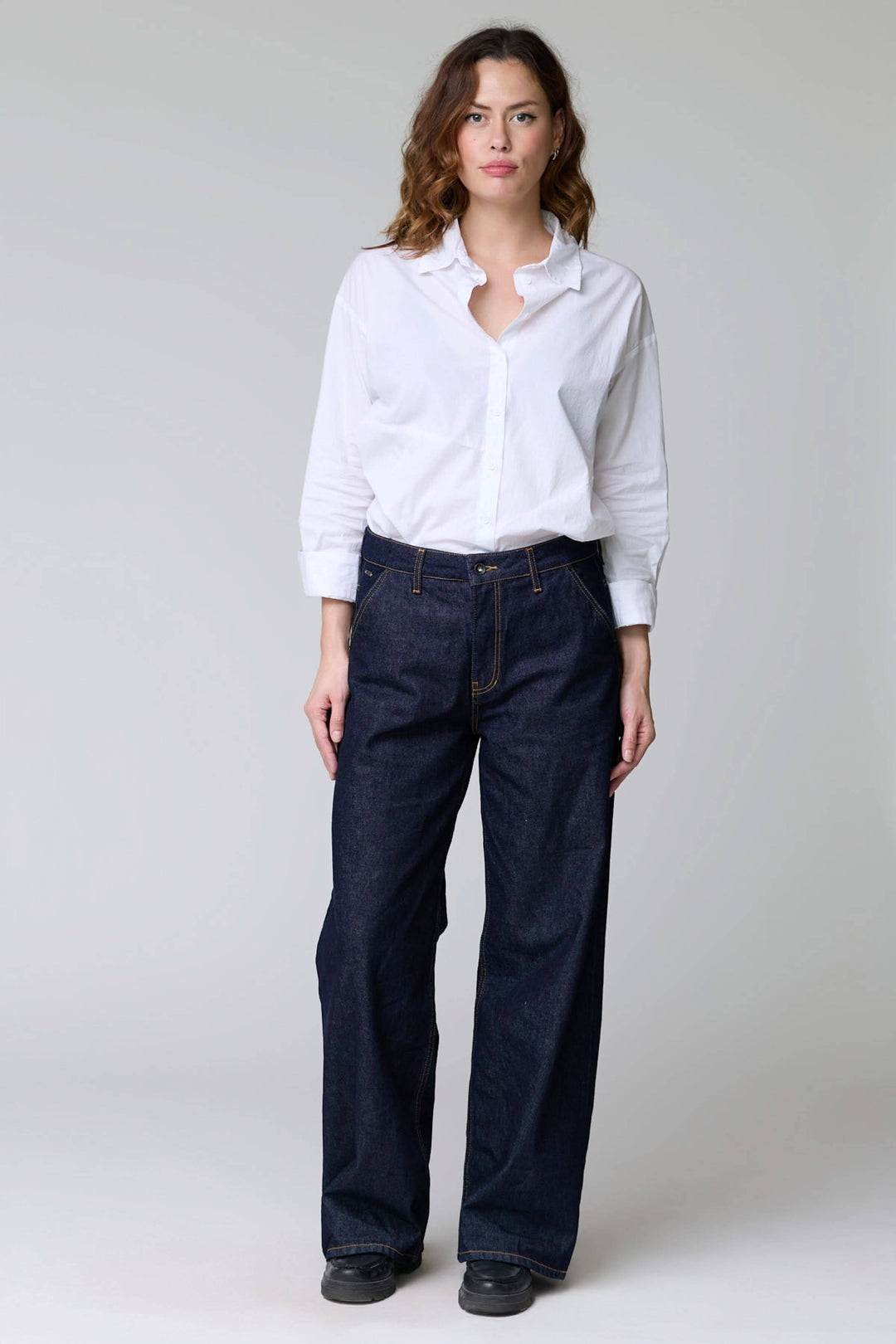 Jean à jambe large en denim brut pour un style décontracté et confort. Coupe ample avec surpiqûres contrastantes, cinq poches.
