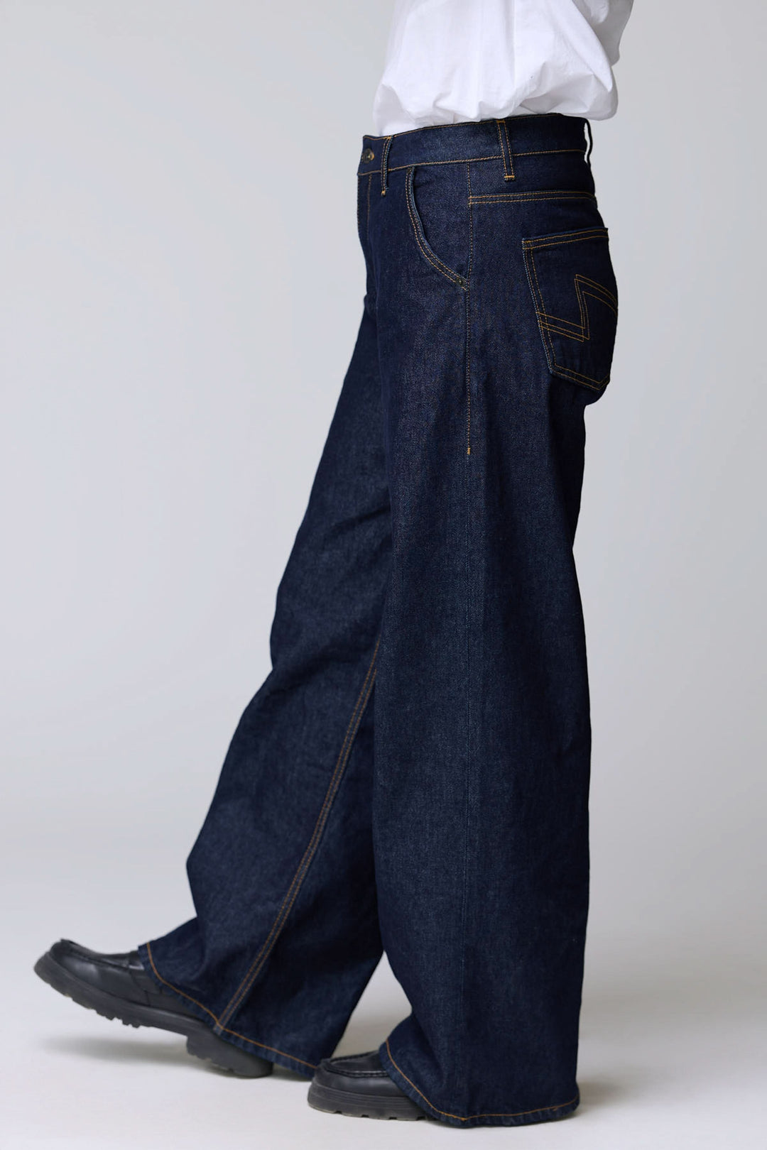 Jean à jambe large en denim rigide, style vintage avec surpiqûres contrastantes, coupe ample et droite offrant confort.