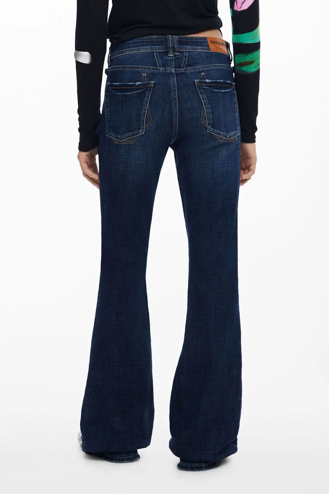 Jean évasé en toile foncée élastique avec taille haute et surpiqûres contrastantes, affichant une élégance décontractée.