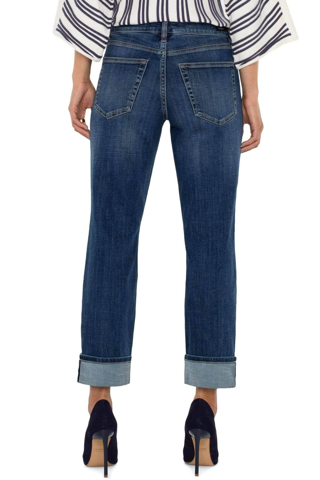 Jean boyfriend Marley avec revers, coupe décontractée, arrière en denim bleu, porté avec des talons.