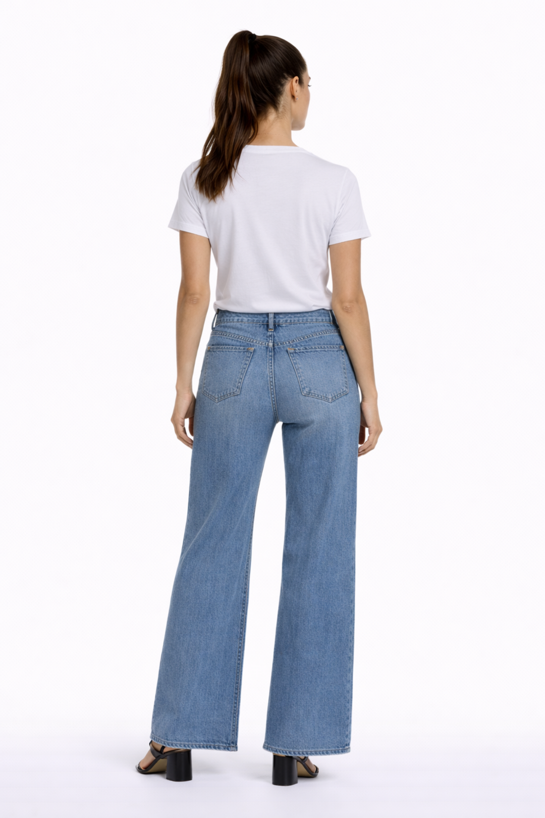 Jeans à coupe droite, taille mi-haute, femme de dos portant un t-shirt blanc, montrant le style moderne et confortable du denim extensible.