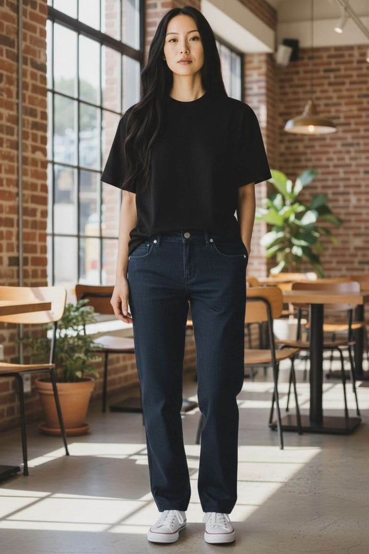Femme portant des jeans coupe droite dans un cadre urbain moderne, mettant en valeur la silhouette nette et un look minimaliste.