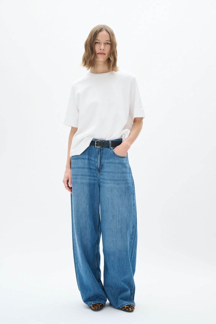 Femme portant des jeans larges Sophia avec un t-shirt blanc, style moderne et élégant.