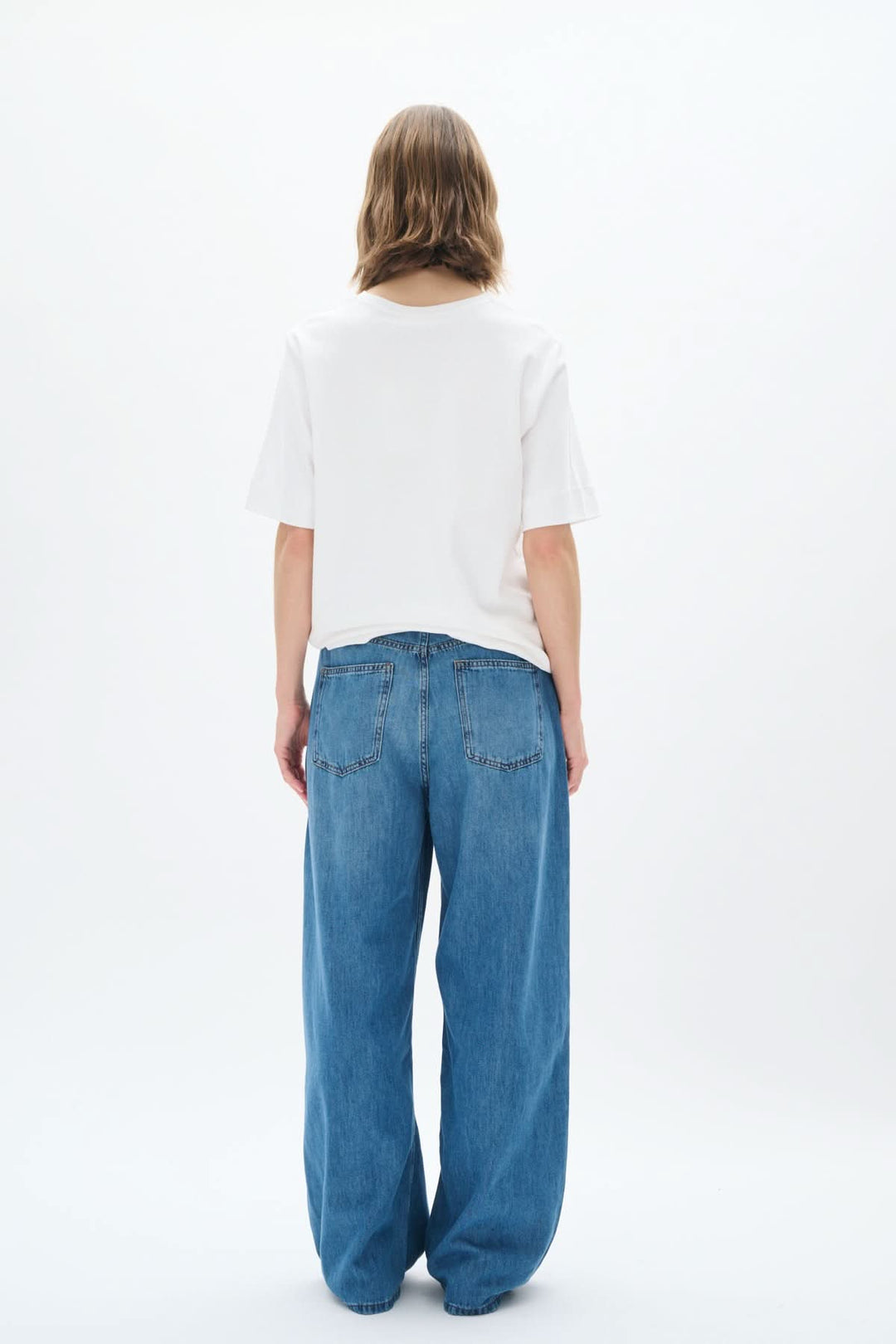 Femme de dos portant des jeans larges Sophia avec t-shirt blanc, style moderne et élégant.