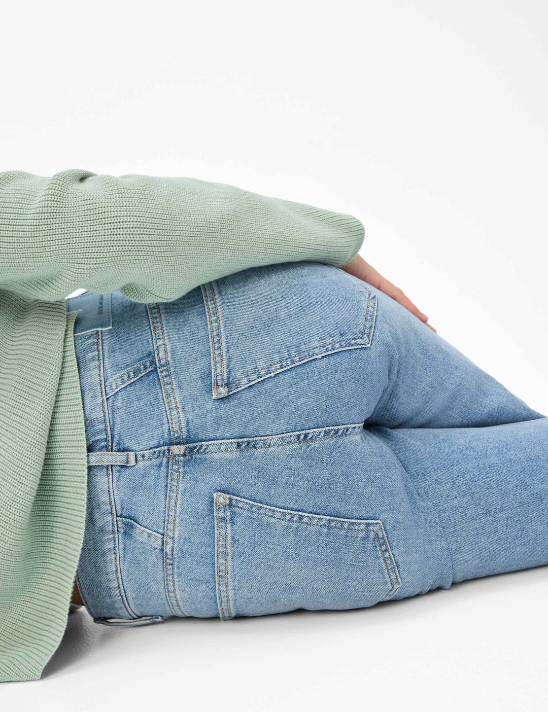 Femme portant des jeans palazzo MAINE, style décontracté avec un pull vert, mettant en valeur la coupe et la couleur du denim.