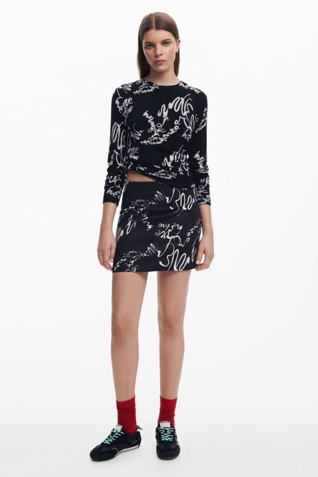 Jupe noire avec imprimé calligraphique blanc, parfaite pour un look moderne et chic.