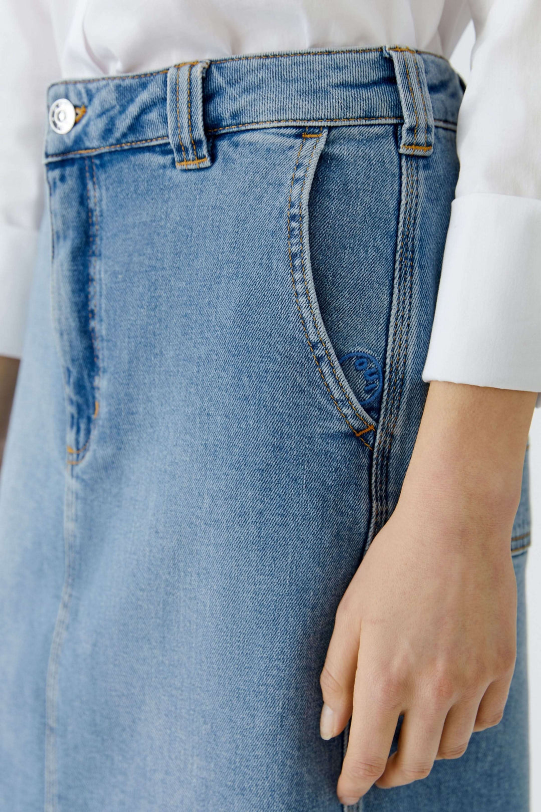 Détail de la jupe en denim classique avec coupe droite et longueur au genou, offrant élégance et polyvalence pour le quotidien.