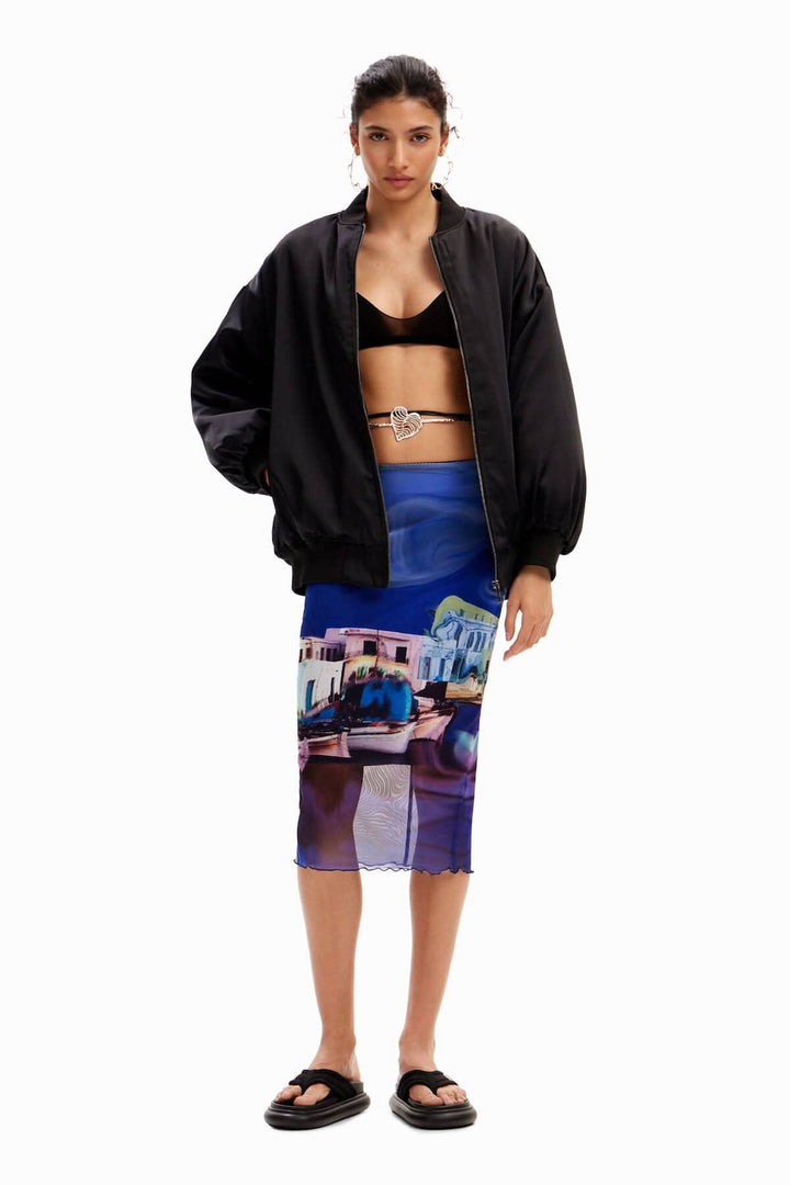 Jupe midi imprimée avec paysage, associée à un haut noir et une veste oversize, modèle posant.